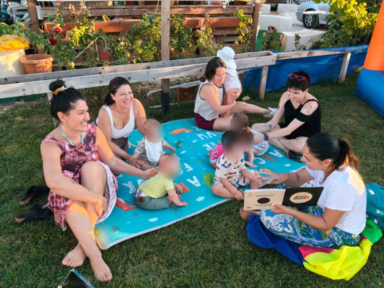 Compleanno all'aperto tra ulivi con tavolo in legno, torta e balle di fieno